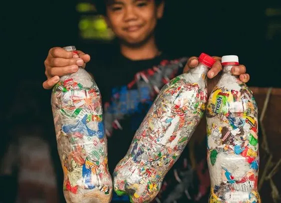Niño sosteniendo tres ecoladrillos