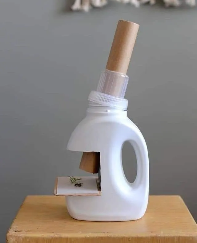Microscopio con botellas y cartón.