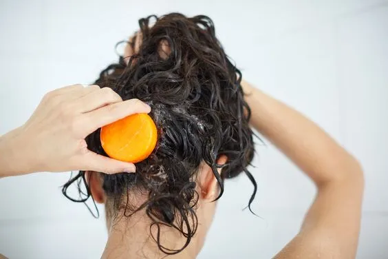 Mujer usando un shampoo sólido.