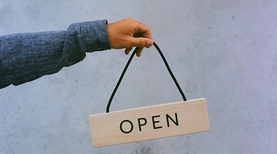 Cartel de "abierto" que hace alusion a empezar tu negocio de ropa de segunda mano